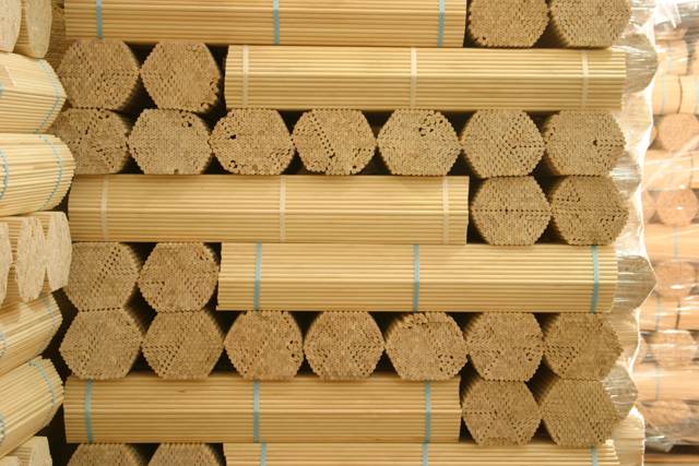 Bulk Wooden Dowels Bundled for High-Volume Manufacturing Bundles of long wooden dowels stacked in rows, prepared for bulk shipment or high-volume manufacturing.