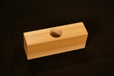 Custom moulded wood block with a precision-drilled hole for specialized applications.