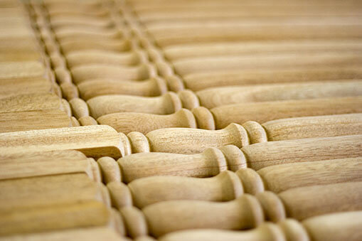 Custom Turned Wood Balusters for Staircases and Architectural Projects Multiple turned wood balusters laid out for inspection, each with unique profiles and smooth finishes.