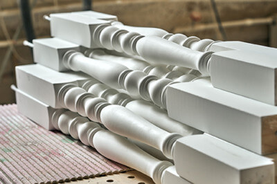 White paint-grade wood stair balusters for an interior railing.