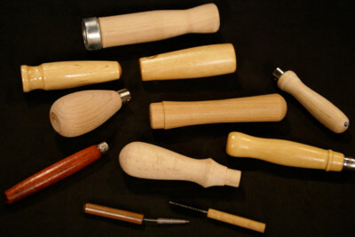 Fifteen custom wood handles in various shapes, sizes, finishes, and wood species, displayed with different hardware and secondary operations.