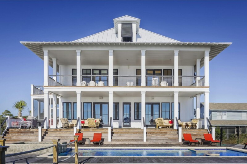 Two-story home with white wood porch columns supporting an upper and lower deck.