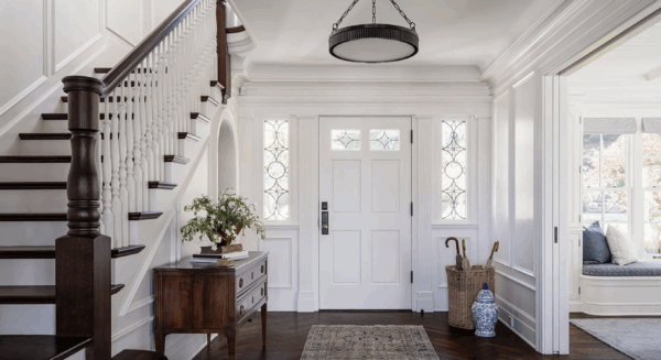 Colonial Staircase with Dark Wood Handrail and White Balusters Refined Colonial staircase with dark wood handrail, white turned balusters, and paneled entryway walls.