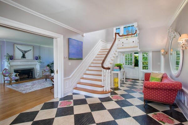 Colonial Home Staircase with Checkered Floor Entryway Colonial-style staircase with turned wood balusters and black-and-white checkered floor in a bright entryway.