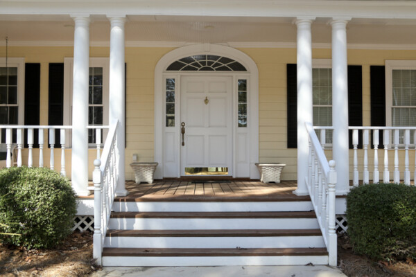 Front porch with round wood columns showcasing a true structural replacement option instead of using temporary porch post wraps.