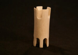 A small wooden knitting tower with intricate turning and routed details.