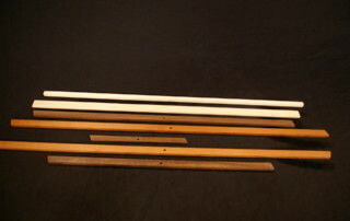 Stacked custom wood mouldings in assorted profiles for large-scale manufacturing projects.