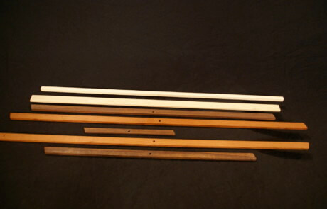 Stacked custom wood mouldings in assorted profiles for large-scale manufacturing projects.