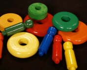 Assorted painted wooden toy parts with child-safe enamel finishes in various bright colors.