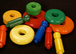 Assorted painted wooden toy parts with child-safe enamel finishes in various bright colors.