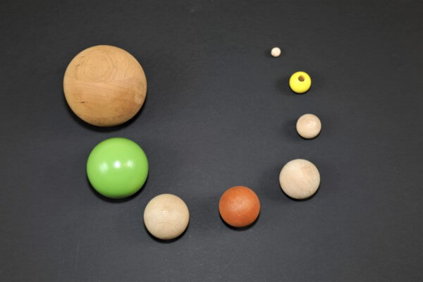 Custom Wooden Balls and Beads with Secondary Operations for Bulk Manufacturing Assorted wooden balls and beads in multiple sizes with drilled holes and flat routing for custom applications.