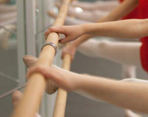 dancers using a wooden ballet barre