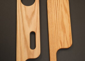 Custom-shaped wood chair arms CNC routed for furniture manufacturing applications.