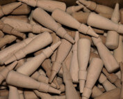 Rows of custom wood handles produced in bulk using automated lathes for high-volume manufacturing.