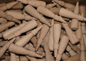 Rows of custom wood handles produced in bulk using automated lathes for high-volume manufacturing.