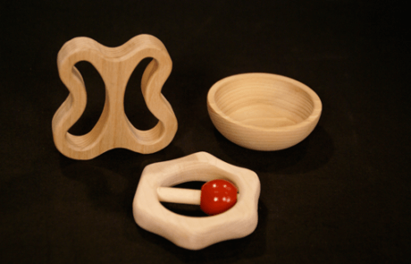 Three custom CNC-routed wood components shaped for use as toy parts, brush blocks, or tool handles.