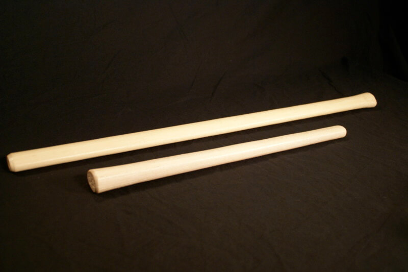 A row of hickory wood striking tool handles, shaped and custom machined for hammers, axes, and sledges.