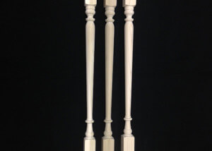Three custom interior wood balusters turned in different profiles for residential staircases.