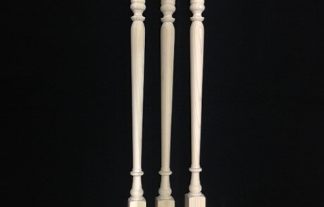 Three custom interior wood balusters turned in different profiles for residential staircases.