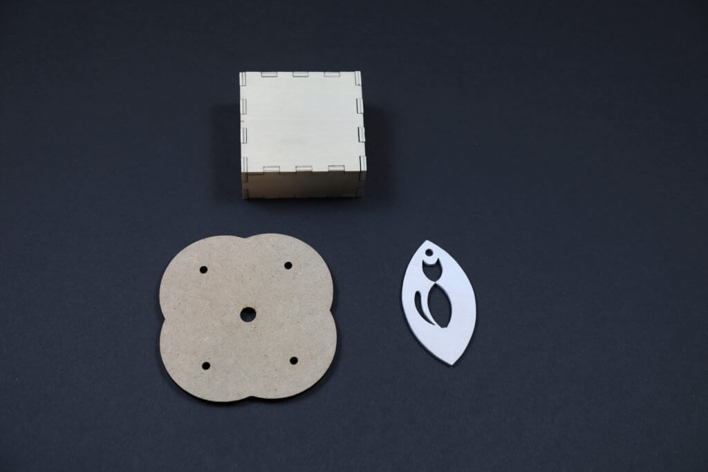 Custom Laser Cut Wood Parts for Bulk Manufacturing and Precision Projects Three precision laser-cut wooden parts in custom shapes with clean edges.