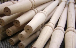 A stack of maple wood balusters custom turned for architectural use.
