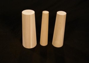 Three custom tapered wooden plugs in different sizes for industrial sealing and manufacturing use.