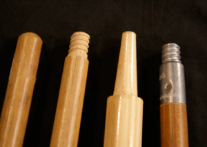 Four wooden broom and mop handles with varied end types including tenoned, tapered, and threaded attachments.
