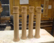 Four custom wood columns with decorative details in various sizes and finishes.