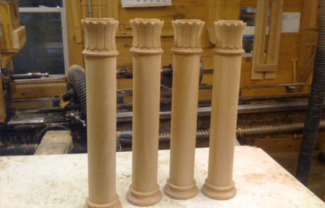 Four custom wood columns with decorative details in various sizes and finishes.
