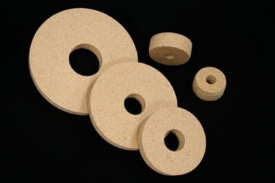 Custom Wood Core Plugs for Bulk Industrial and Papermaking Applications Five round wooden core plugs in various sizes made from particle board.