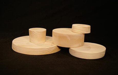 Three custom wooden bungs designed for sealing paper tubes in shipping and packaging applications.