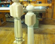 Two custom wooden newel posts with traditional profiles used for stair rail support and decorative architecture.