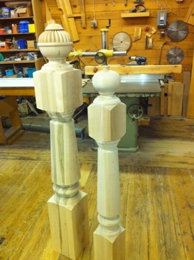 Two custom wooden newel posts with traditional profiles used for stair rail support and decorative architecture.