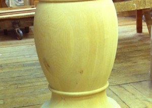 Custom turned wooden pedestal column for supporting tables, kitchen islands, or architectural elements.