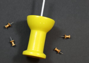 Large and small custom wooden push pin barrels shown side by side on a wooden surface.
