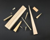 Assorted wooden wedges in various sizes and thicknesses made for industrial and utility applications.