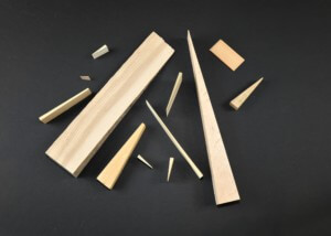 Assorted wooden wedges in various sizes and thicknesses made for industrial and utility applications.