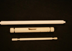 Assorted wood dowels and turned components featuring secondary operations such as holes, tapers, and tenons.