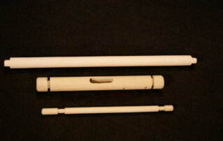 Assorted wood dowels and turned components featuring secondary operations such as holes, tapers, and tenons.