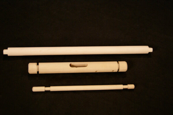 Assorted wood dowels and turned components featuring secondary operations such as holes, tapers, and tenons.
