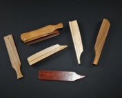 Assorted custom wooden game calls in various shapes and sizes displayed on a table.