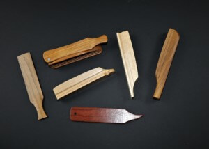 Assorted custom wooden game calls in various shapes and sizes displayed on a table.