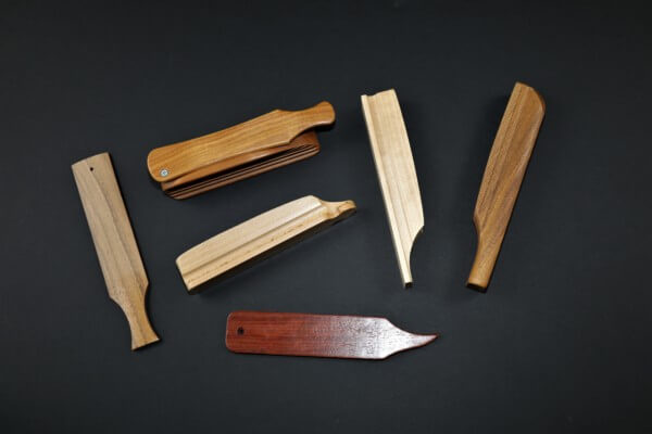 Assorted custom wooden game calls in various shapes and sizes displayed on a table.
