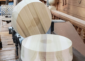 Two large diameter wooden plugs on concrete surface, used in custom municipal and industrial applications.
