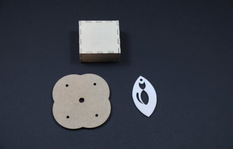 Assorted laser-cut wood parts with various shapes and cutouts for bulk manufacturing applications.