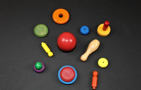 Assorted custom-painted wooden turnings in bright colors made for bulk orders and safety-compliant uses.