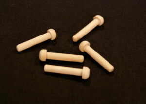 Five custom wooden pegs used in toy vehicles, furniture, and specialty wood products.