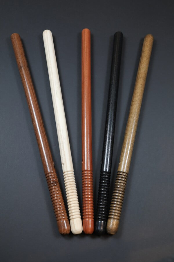 Five wooden police batons with beaded grips in a row, made from finished hardwood.