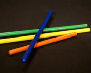 Assorted small wooden dowels in multiple colors, custom finished for bulk orders.