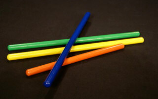 Assorted small wooden dowels in multiple colors, custom finished for bulk orders.